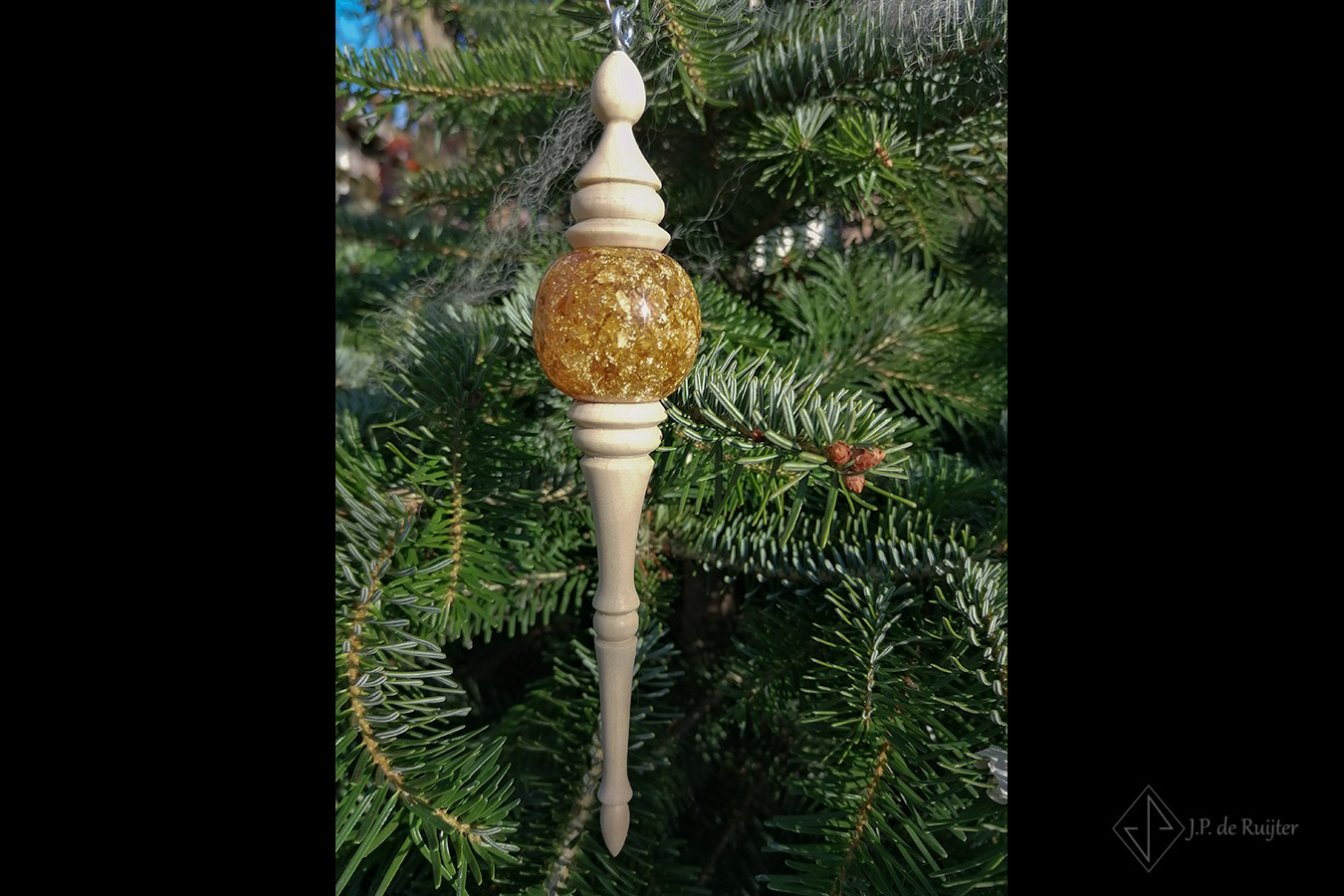 Sierlijk in ronde vormen gedraaid kerst ornamen van hout met goudglitters bal van epoxy. Deze hangt in de kerstboom.