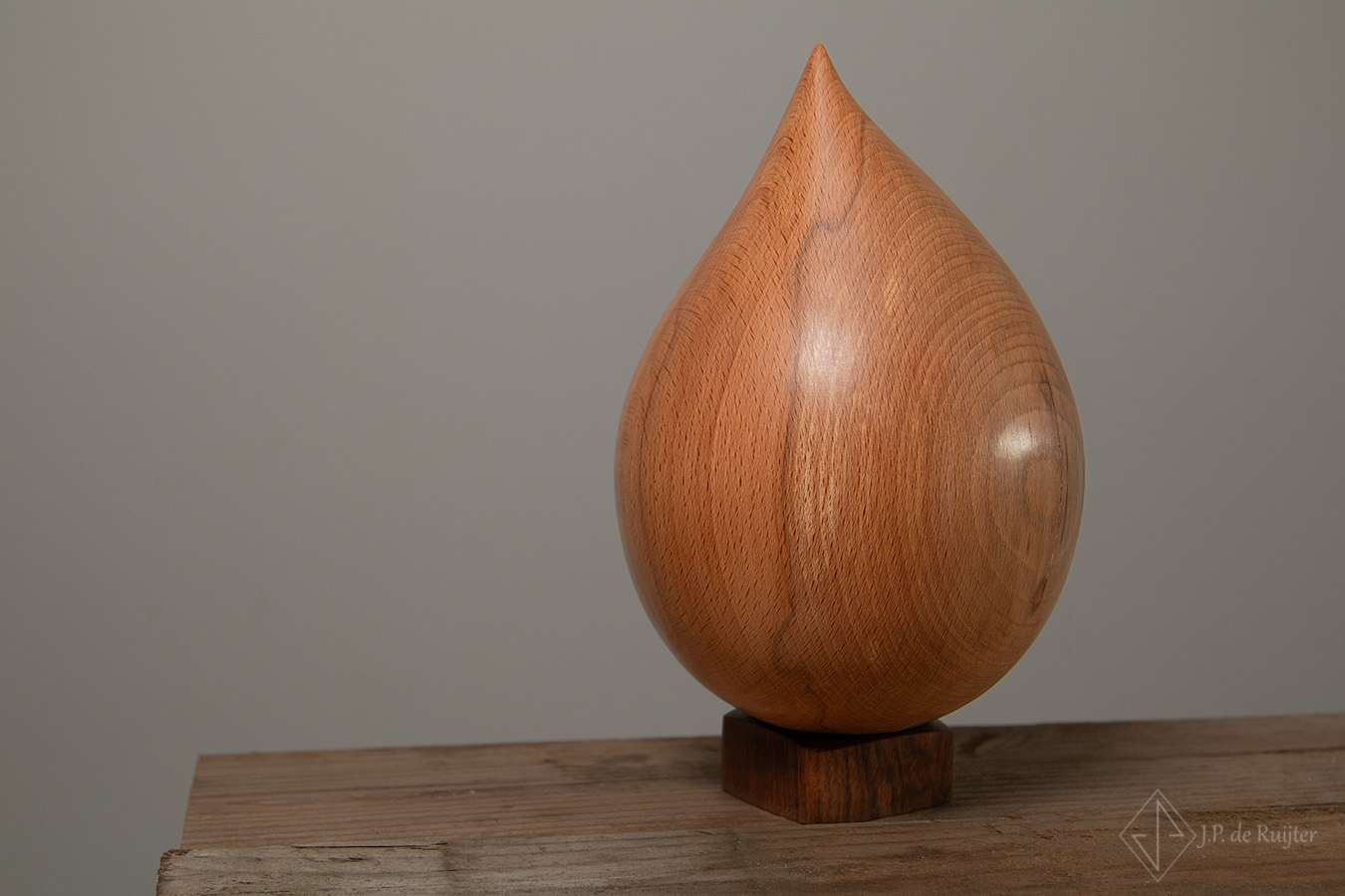 Urn van hout in een asymmetrische druppel vorm. Beuken hout met een gladde warme uitstraling.