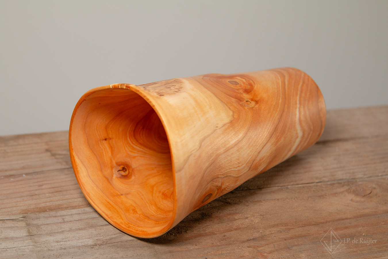 Liggende vaas. Hier zijn de mooie vervormingen van deze houten vaas uit kersen hout goed te zien. Hij is dun en een mooi stuk voor in elk interieur. 
