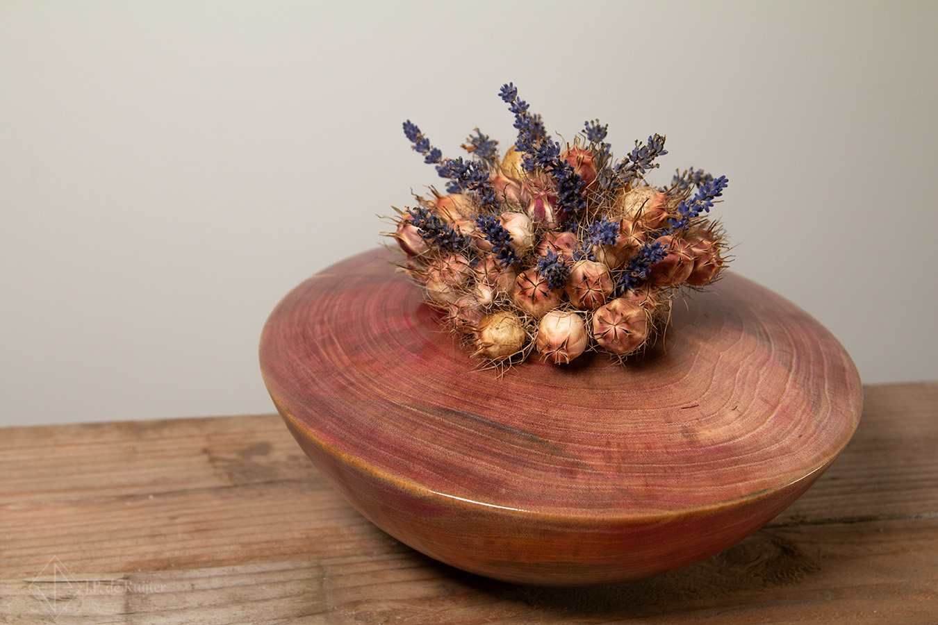 Vaas in schaal vorm gekleurd met magenta van walnoten hout in ufo vorm. Op deze vaas kunnen droog, zijde en kunst bloemen. Zonder bloemen is het een kleurrijk kunst object van hout.
